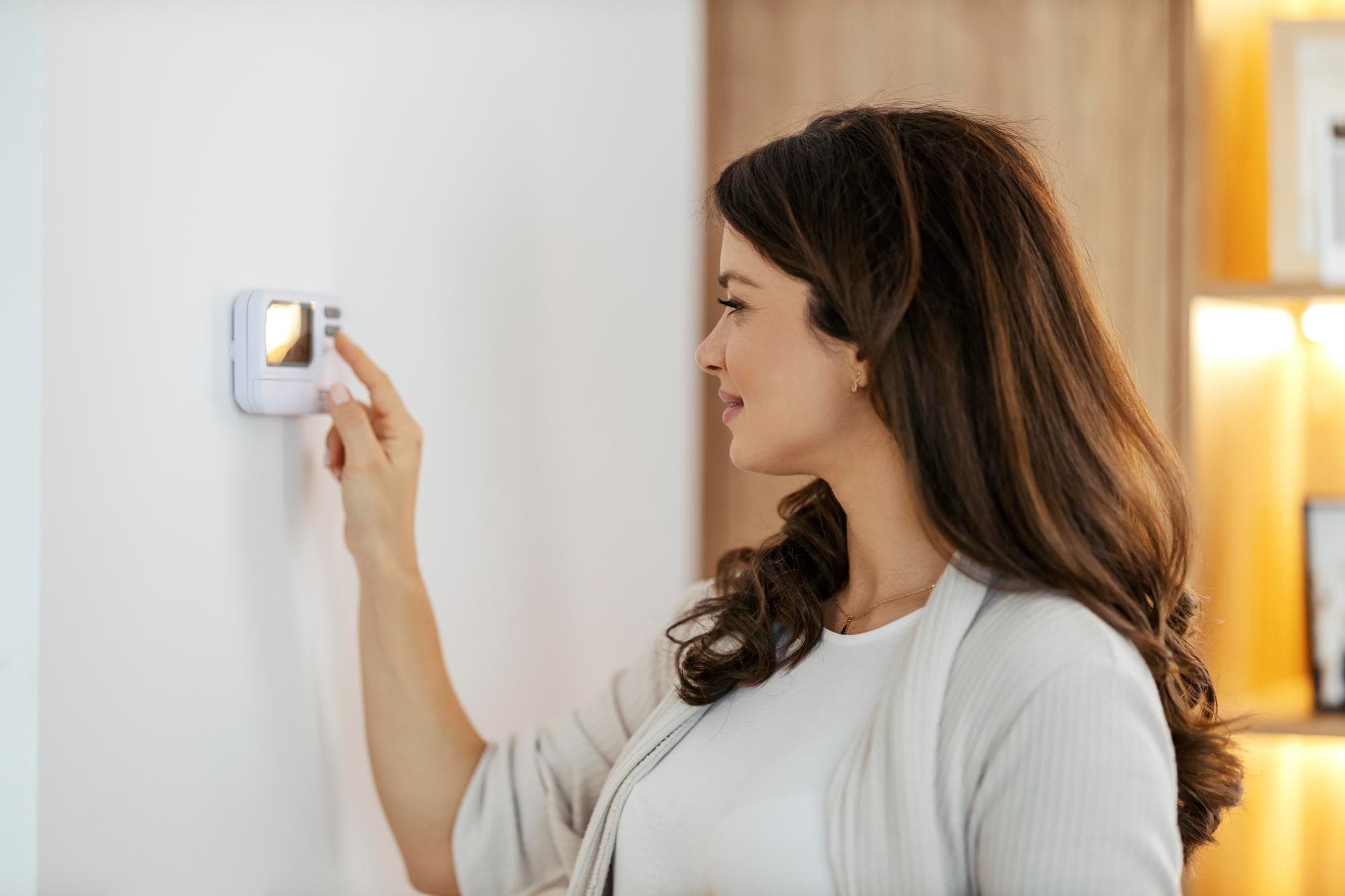 mujer ajustando termostato